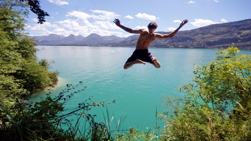 Guy jumping off cliff into water